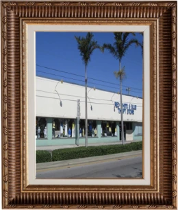 Framed photo of the first Red White & Blue Thrift store building with text below: 1965, Company Founded.