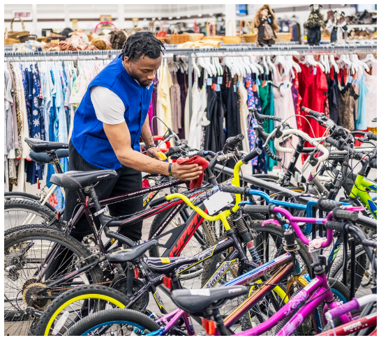 RWB Thrift employee arranging bicycles in the store’s sales floor.
